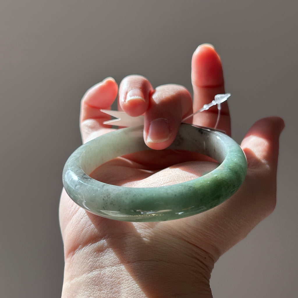 Floating green Burmese jadeite bangle with black chicken (wuji), 58.6mm, photo 1 - Luxe Jadeite