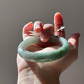 Floating green Burmese jadeite bangle with black chicken (wuji), 58.6mm, photo 1 - Luxe Jadeite